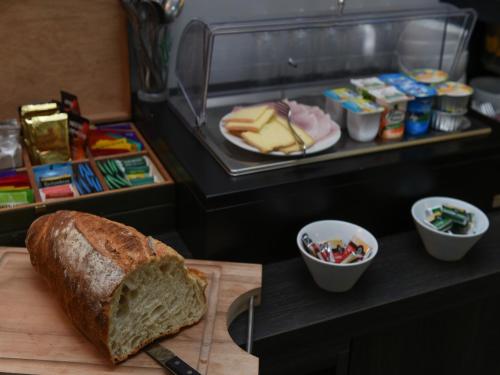 een brood op een snijplank met een sandwich bij Auberge des Moulins in Baume-les-Dames