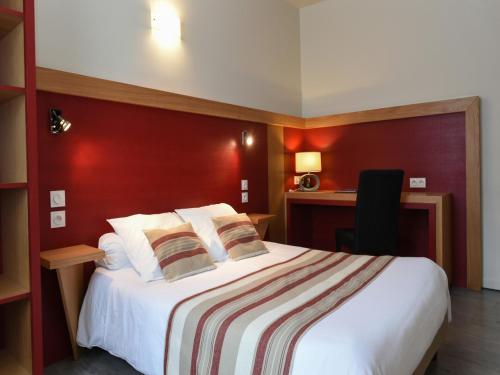 Cette chambre dispose d'un grand lit avec un mur rouge. dans l'établissement Auberge des Moulins, à Baume-les-Dames