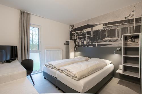 a bedroom with a bed and a tv in it at FairSleep Avia Motel Gmünd in Gmünd