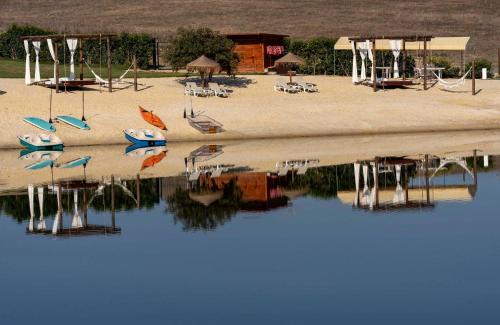 a group of boats sitting on the sand next to the water at Monte Vale - Nature Resort in Entradas