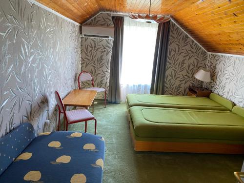a living room with a green couch and a table at Rózsa Vendégház Balatonfüred in Balatonfüred