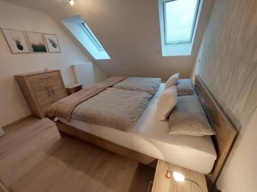 1 dormitorio pequeño con 1 cama y 2 ventanas en Bilsteinquelle, en Bad Wildungen
