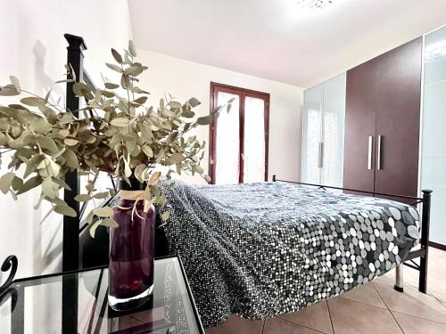 a bedroom with a bed and a vase with a plant at Locazione Turistica Casa LALLI in Pieve a Maiano
