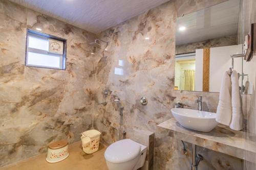 a marble bathroom with a sink and a toilet at Casa Majestic Resort and SPA in Panchgani