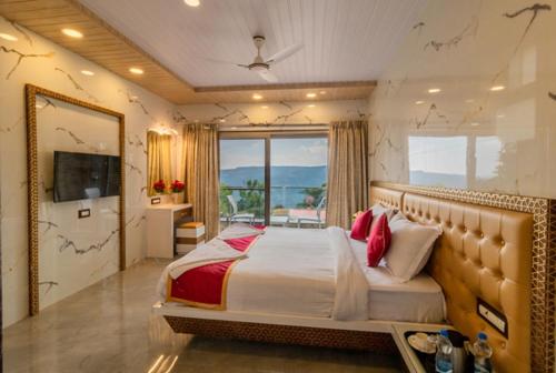 a bedroom with a large bed and a large window at Casa Majestic Resort and SPA in Panchgani