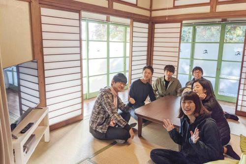 a group of people sitting around a table in a room at Forest Villa Hakone in Hakone