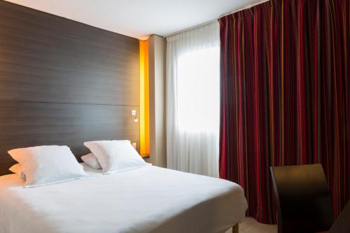 une chambre d'hôtel avec un lit et une fenêtre dans l'établissement Hôtel Oceania Nantes Aéroport, à Bouguenais