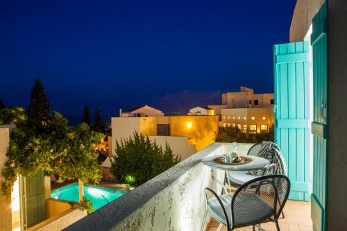 a balcony with a table and chairs at night at Villa Iokasti in Hersonissos