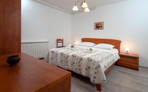 a bedroom with a bed and a wooden table at Apartments Ena in Vrboska
