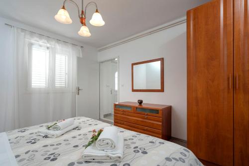 a bedroom with a bed and a dresser and a mirror at Apartments Ena in Vrboska