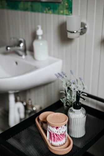 a bathroom counter with a sink and a tray with a vase at Ursa Mica Glamping Resort in Şirnea