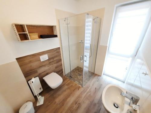 a bathroom with a shower and a toilet and a sink at Ferienwohnung Nordlicht in Barth