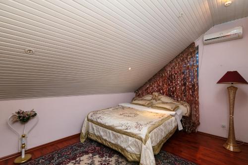 a small bedroom with a bed in a attic at Hotel EZIO in Chişinău