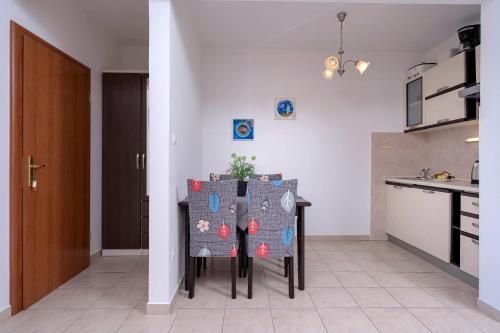 a kitchen with a table and chairs in a room at Apartments Ena in Vrboska