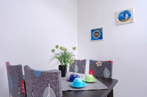 a dining room table and chairs with blue and green dishes on it at Apartments Ena in Vrboska