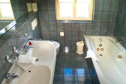 a bathroom with a tub and a toilet and a sink at Holiday Home Witsum - DNS10055-F in Hedehusum