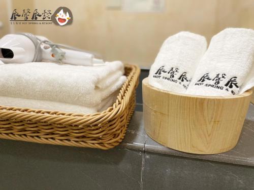 two baskets of towels on a counter with writing on them at 辰馨辰懿溫泉會館 in Jiaoxi
