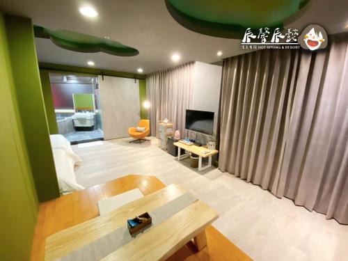 a living room with a couch and a table at 辰馨辰懿溫泉會館 in Jiaoxi