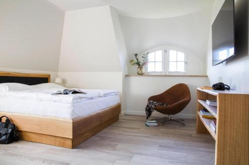 1 dormitorio con 1 cama y 1 silla en Holiday house, Fuhlendorf en Fuhlendorf