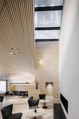 a lobby with tables and chairs and a fireplace at Peterhof Chalets in Batschuns