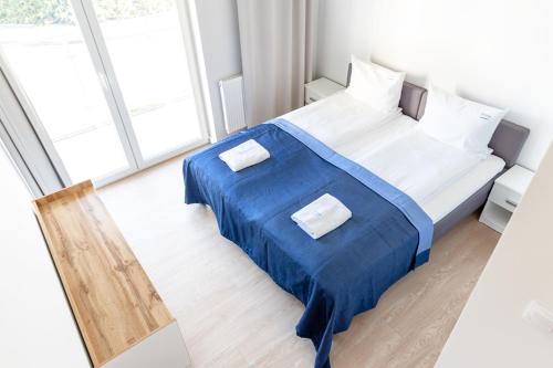 1 dormitorio con 1 cama grande con manta azul en AL-DOM apartamenty Apartament Stjarne, en Kołobrzeg