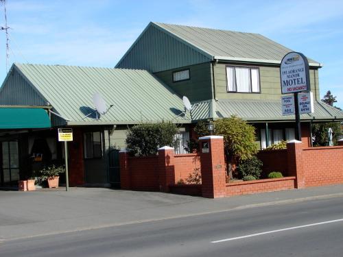 a house with a green roof on a street at 193 Aorangi Manor Motel in Blenheim