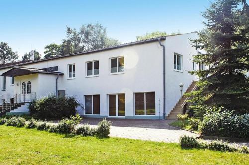 a white house with a tree in front of it at Reihenhaus Seeblick, Sommersdorf in Sommersdorf