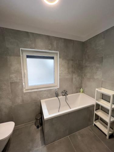 a bathroom with a bath tub and a window at Abra Apartament in Poznań