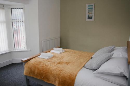 a bedroom with a bed with two towels on it at Six Bells Retreat in Abertillery