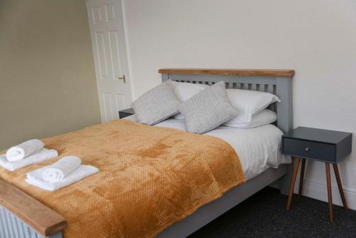 a bedroom with a bed with two towels on it at Six Bells Retreat in Abertillery
