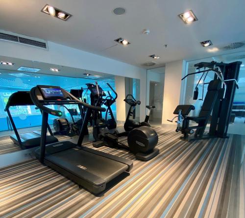 einen Fitnessraum mit mehreren Laufbändern in einem Zimmer in der Unterkunft Crowne Plaza Düsseldorf - Neuss, ein IHG Hotel in Neuss