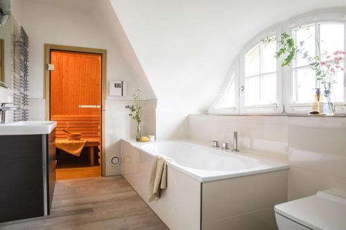 a bathroom with a large white tub and a window at Holiday house, Fuhlendorf in Fuhlendorf