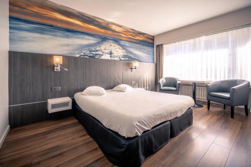 a hotel room with a bed, chair, desk and a painting on the at Hotel Royal Astrid in Ostend