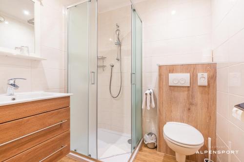a bathroom with a shower and a toilet and a sink at Gasthof Alpensport - inklusive Joker Card in Saalbach-Hinterglemm