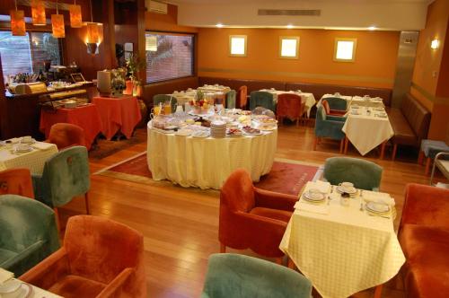 a dining room filled with tables and chairs with at Hotel Central Parque in Maia