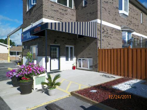 a building with two potted plants in front of it at Sunparlor Motel in Leamington