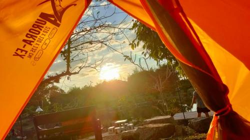 vista sul sole dall'interno di una tenda di บ้านย่า ณ ท่าไทร a Si Racha