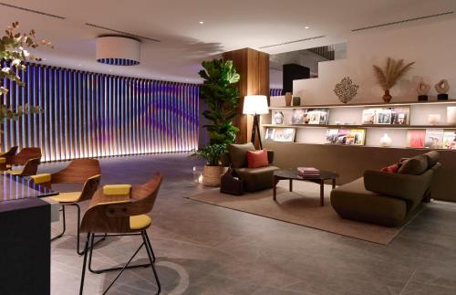 a lobby with chairs and tables and a large window at ME Barcelona in Barcelona