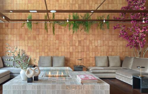 a living room with couches and a table and flowers at ME Barcelona in Barcelona