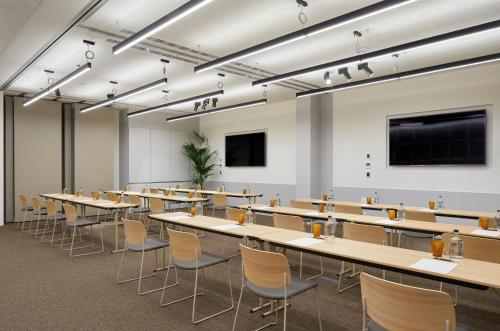 a room with tables and chairs in a classroom at ME Barcelona in Barcelona