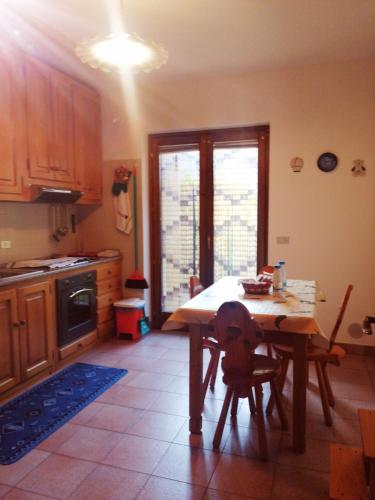 a kitchen with a wooden table and a table and chairs at NUS-SCI-CASTELLO-ASTRONOMIA-CASINO' in Nus