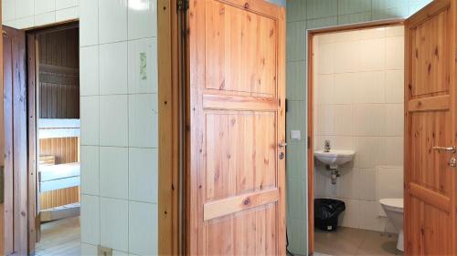 a bathroom with a toilet and a wooden door at Tapa Sauna House in Tapa