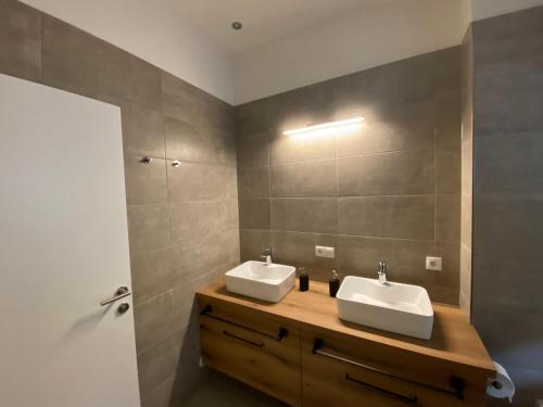łazienka z 2 umywalkami i lustrem w obiekcie Sun Hill w Schladming