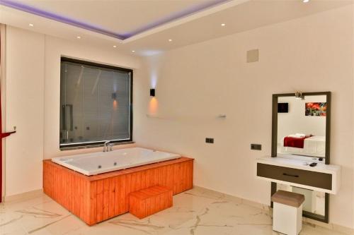 カシュにあるVilla Olivet-Kalkan 3 Bedroom-2 Jakuzzies-Sauna-Turkish Hamam-Huge Private Pool and lovely gardenのバスルーム(大型バスタブ、窓付)