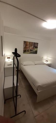 a white bedroom with a bed and a night stand at CASTELLO Ground Floor in Venice