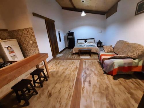 a living room with a couch and a bed at Chalé Filhos da Terra in São Francisco Xavier