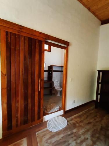 an open door to a bathroom with a toilet at Chalé Filhos da Terra in São Francisco Xavier