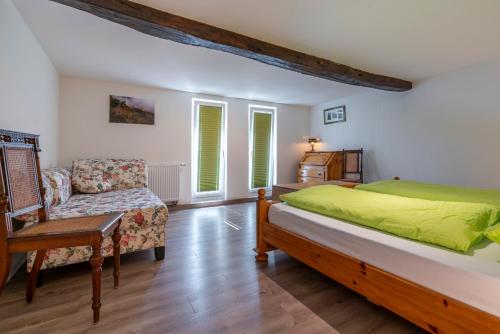 a bedroom with a bed and a couch and a chair at Andun´s in Boppard