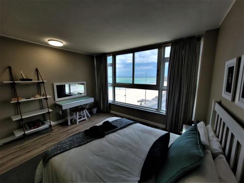 a bedroom with a bed with a view of the ocean at On The Beach At Strand in Strand