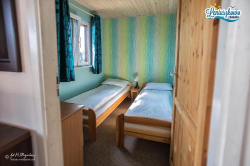 a small room with two beds and a window at Domki letniskowe LENIUSZKOWO in Bobolin
